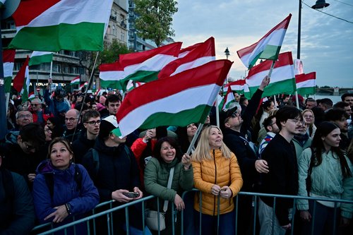 People hold Hungarian flags, as they wait for Peter Magyar, leader of the opposition Tisza party, on the day of the parliamentary election, in Budapest, Hungary, April 12, 2026. REUTERS/Marton Monus