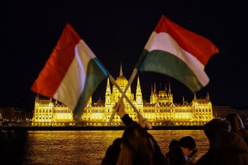 A person holds up Hungarian flags