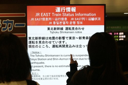 People look at an electronic display announcing suspension