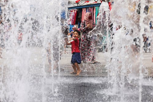 A child plays in the wall of water fountain in the Old City of Tunis