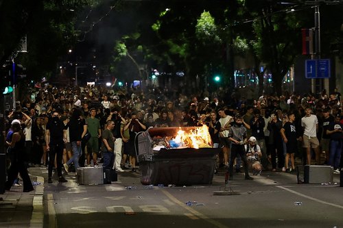 Demonstrators stand in a road by a fire, during a studen