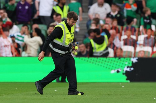 Soccer Football - International Friendly - Republic of Ireland v Qatar - Aviva Stadium, Dublin, Ireland - May 28, 2026 A steward collects tennis balls which were thrown onto the pitch as part of a protest during the match REUTERS/Cathal Mcnaughton
