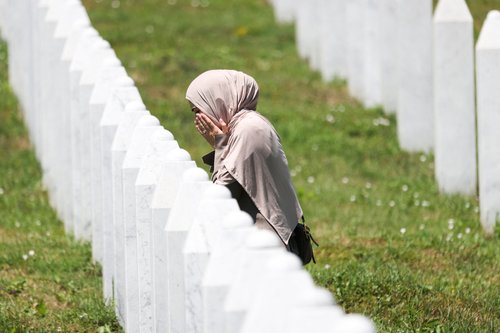 A Bosnian woman prays as she walks among gravestones of victims during preparations for the 31st anniversary of the Srebrenica genocide, in Potocari, Bosnia and Herzegovina, July 10, 2026. REUTERS/Amel Emric