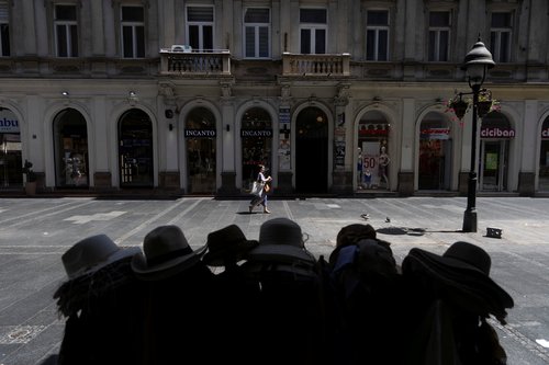 A woman walks next to a hat stand during a heatwave in Belgrade, Serbia, June 29, 2026. REUTERS/Djordje Kojadinovic