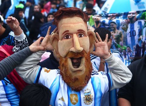 Soccer Football - FIFA World Cup 2026 - Argentina players arrive in Buenos Aires after the final - Buenos Aires, Argentina - July 20, 2026 Argentina fan wearing a Lionel Messi mask gestures as supporters gather outside the Argentine Football Association (