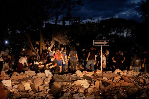 People dig through debris at the site of a collapsed building as recovery efforts continue at night following an earthquake, in Cali, Colombia August 10, 2026. REUTERS/Christian EscobarMora TPX IMAGES OF THE DAY