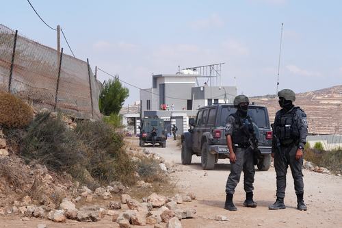 Members of the Israeli security forces stand guard near a Palestinian house, which was besieged by Israeli settlers, in Qusra, in the Israeli-occupied West Bank, August 14, 2026. REUTERS/Ali Sawafta
