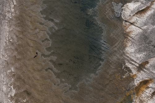 A drone view of a man walking on exposed parts of the riverbed of the Danube River at record-low water levels, in Ruse, Bulgaria, August 13, 2026. REUTERS/Stoyan Nenov