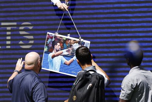 Tennis - U.S. Open - Flushing Meadows, New York, United States - August 25, 2026 Serbia's Novak Djokovic signs autographs for fans after his mixed doubles round of 16 match with Belarus' Aryna Sabalenka against Britain's Henry Patten and Czech Republic's