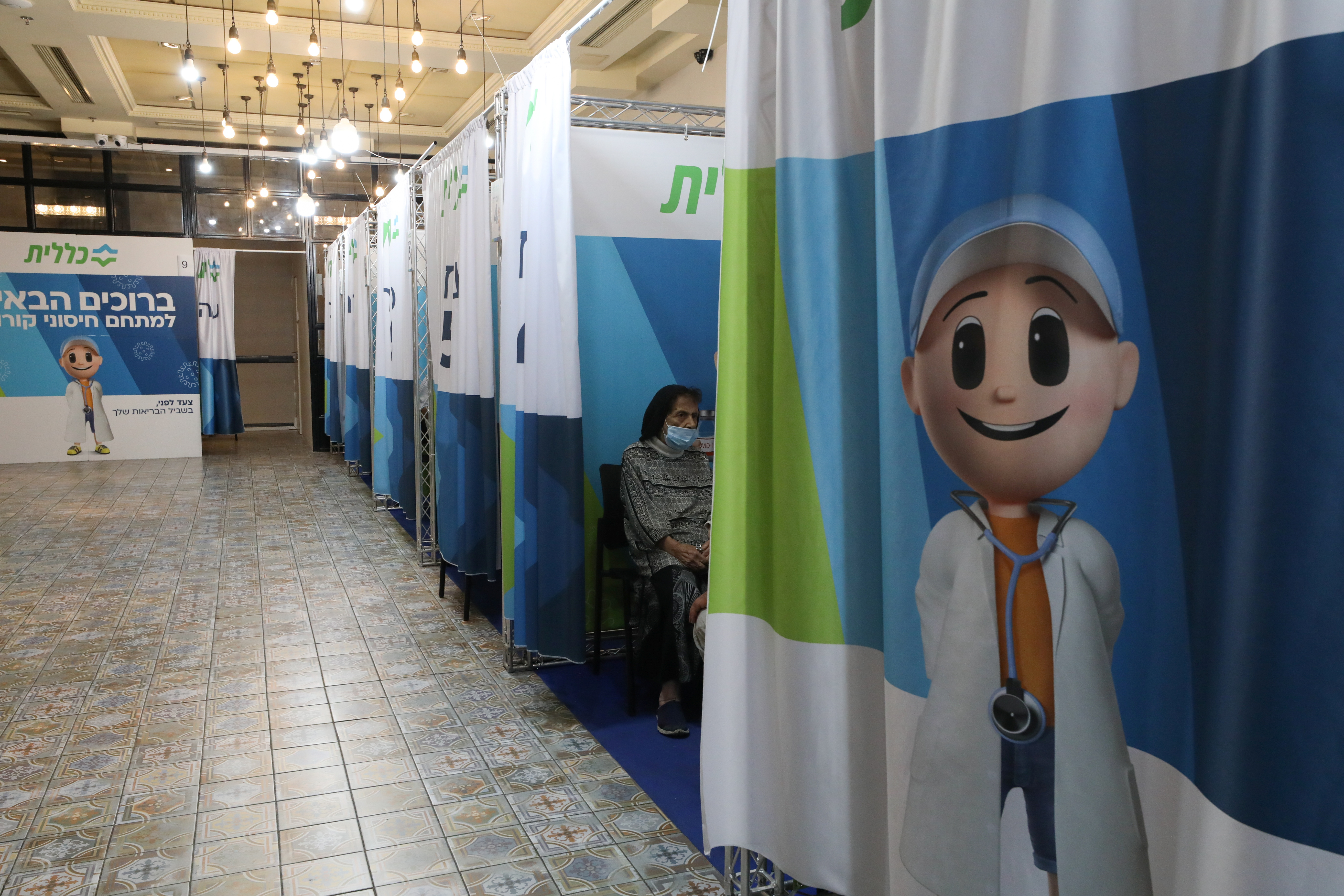 A woman receives her third dose of the coronavirus disease (COVID-19) vaccine at a Clalit healthcare maintenance organisation in Jerusalem