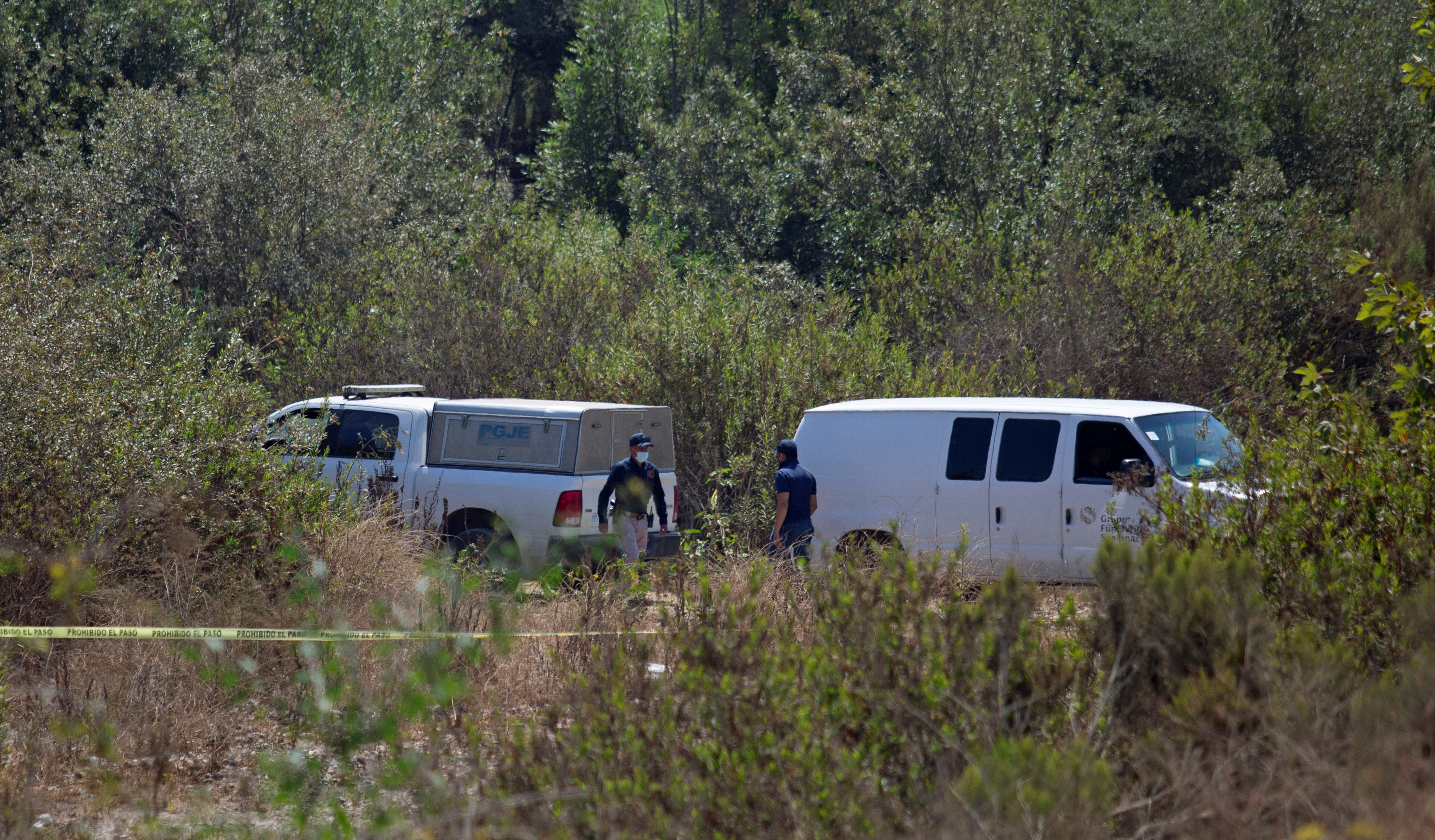 Forensic technicians work at the scene where two American children were found dead in Rosarito
