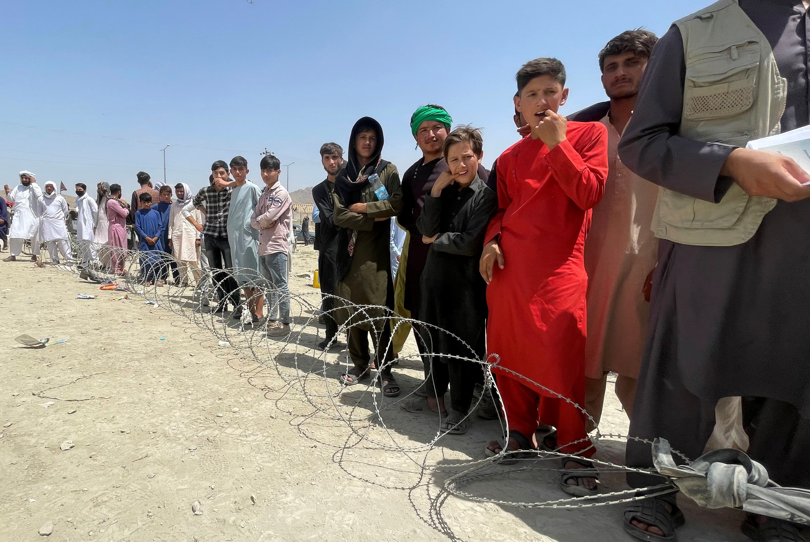People wait outside Hamid Karzai International Airport in Kabul