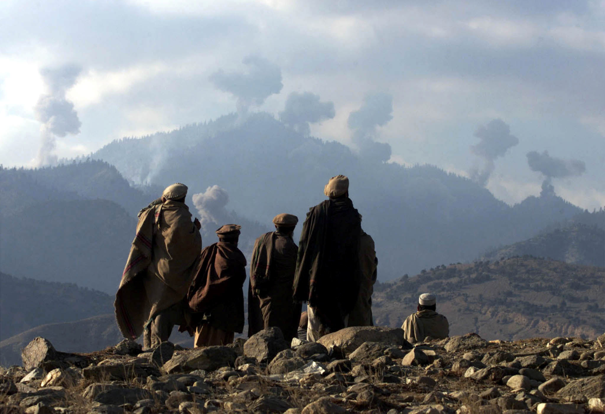 FILE PHOTO: Anti-Taliban Afghan fighters watch several explosions from U.S. bombings in the Tora Bora mountains ..