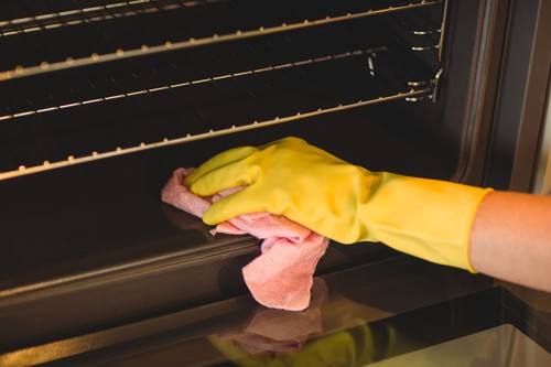 Person cleaning the oven