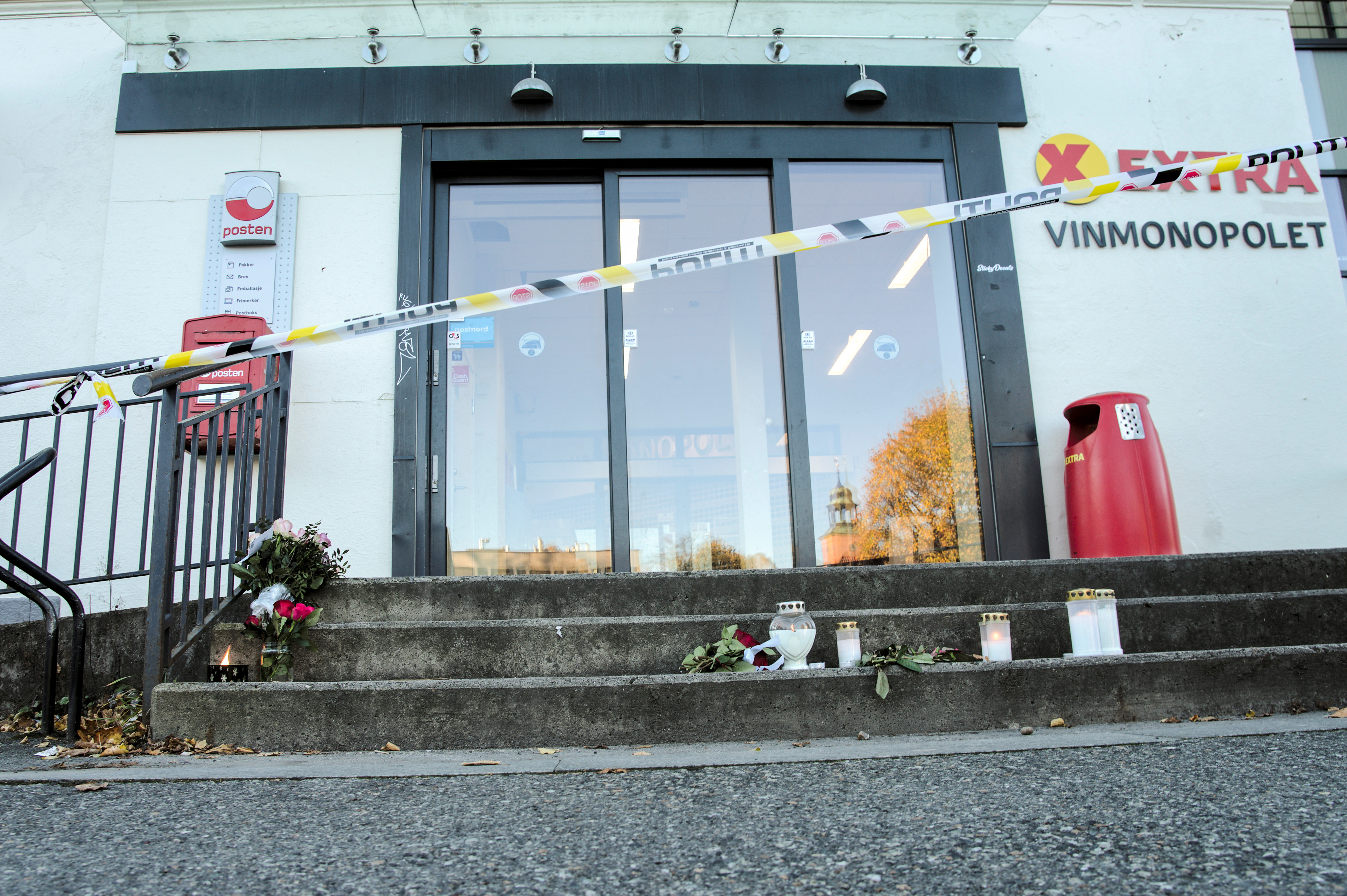 People lay down flowers and light candles after a deadly attack, in Kongsberg