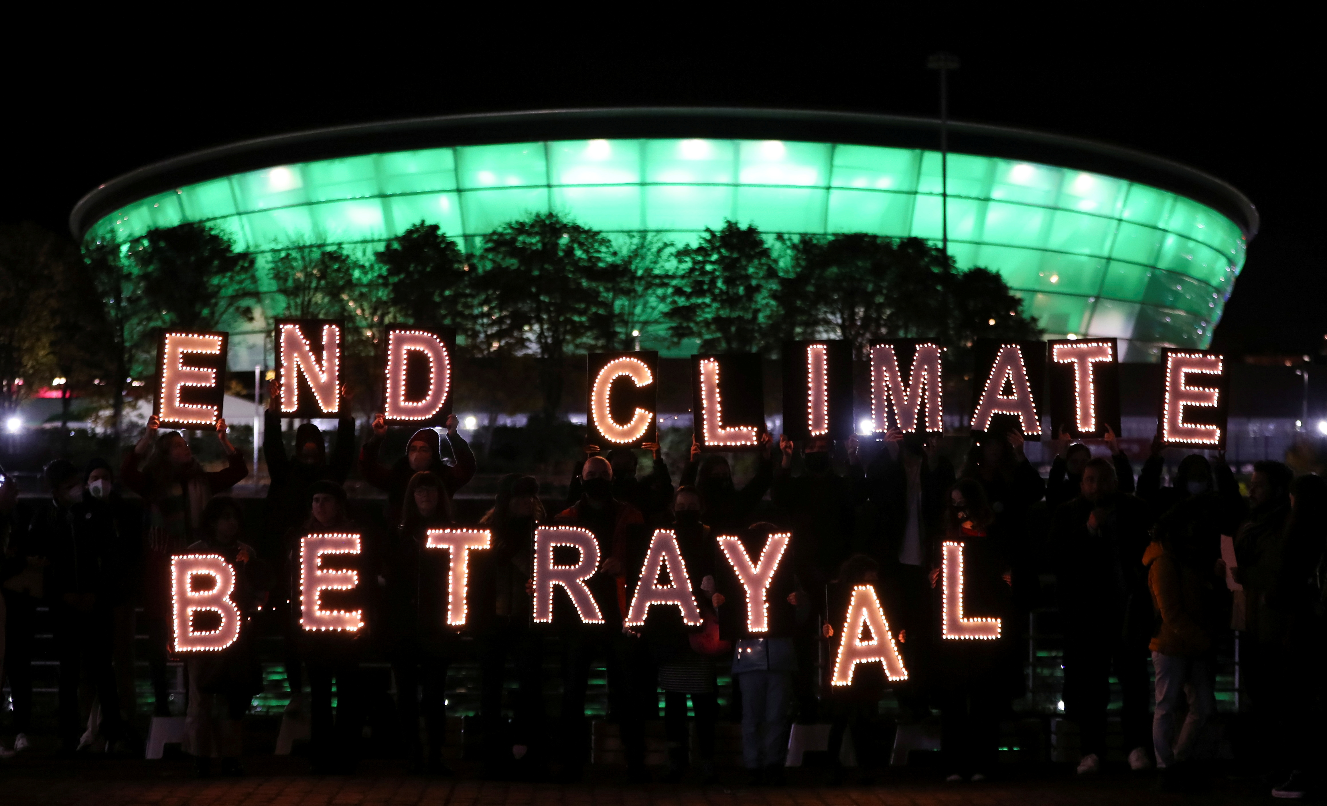 Climate youth activists display a message during a protest opposite the venue for COP26 in Glasgow