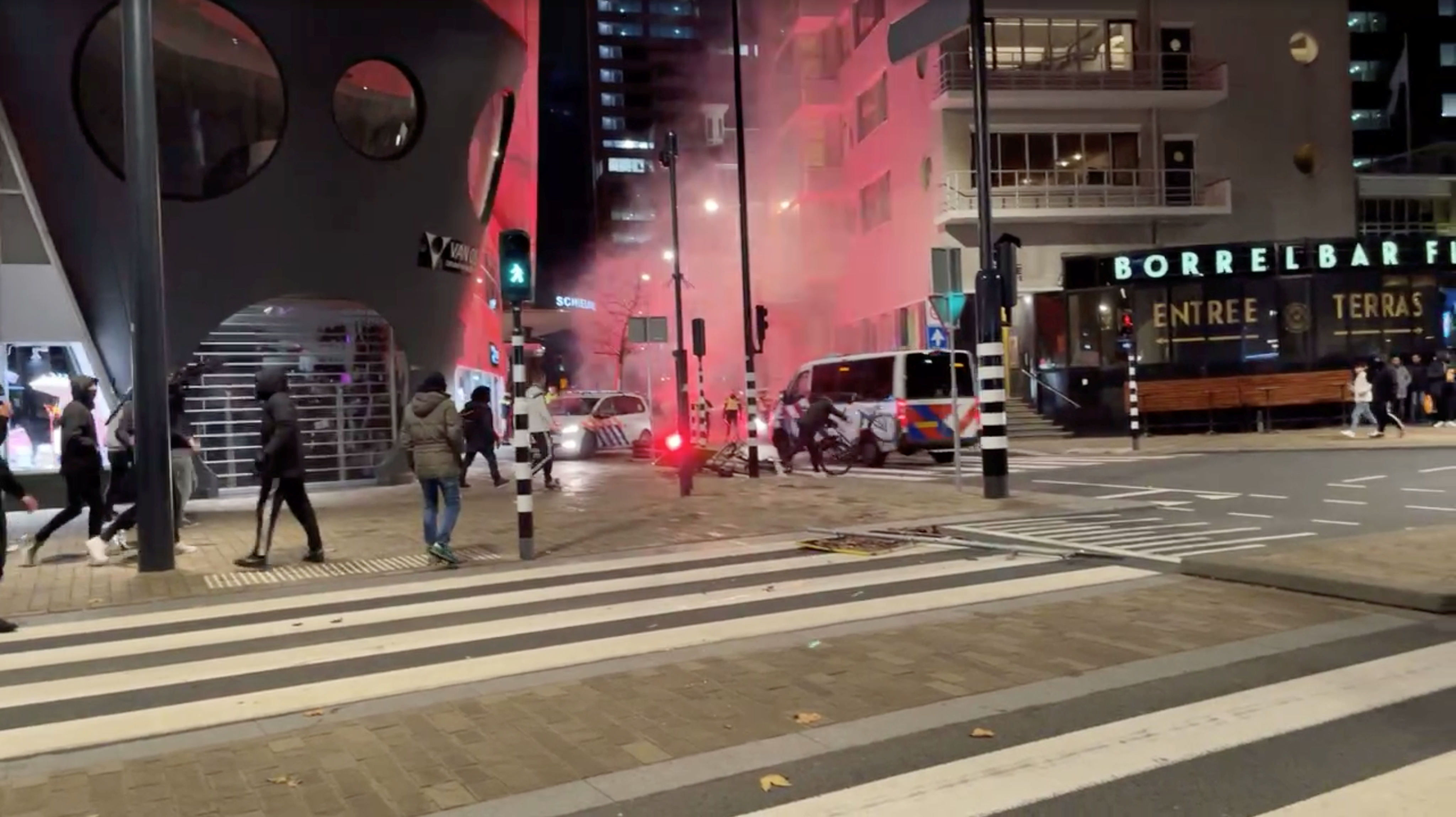 A protester throws a bicycle at a police vehicle in Rotterdam