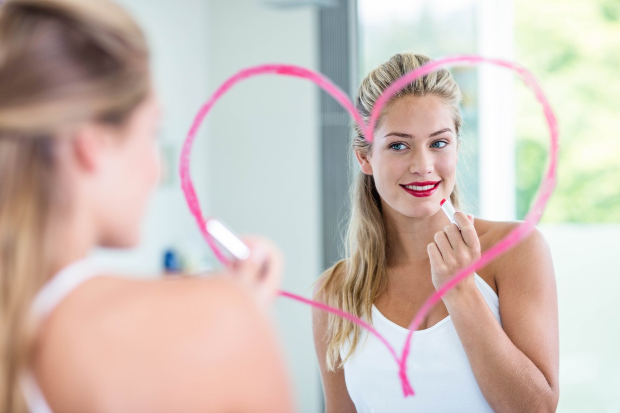 Woman with lipstick looking in the mirror