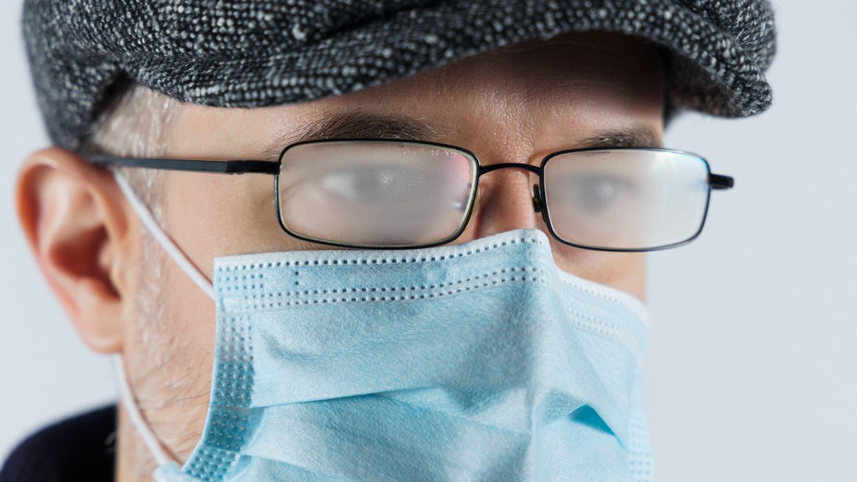 Man with foggy glasses caused by wearing a covid protective mask
