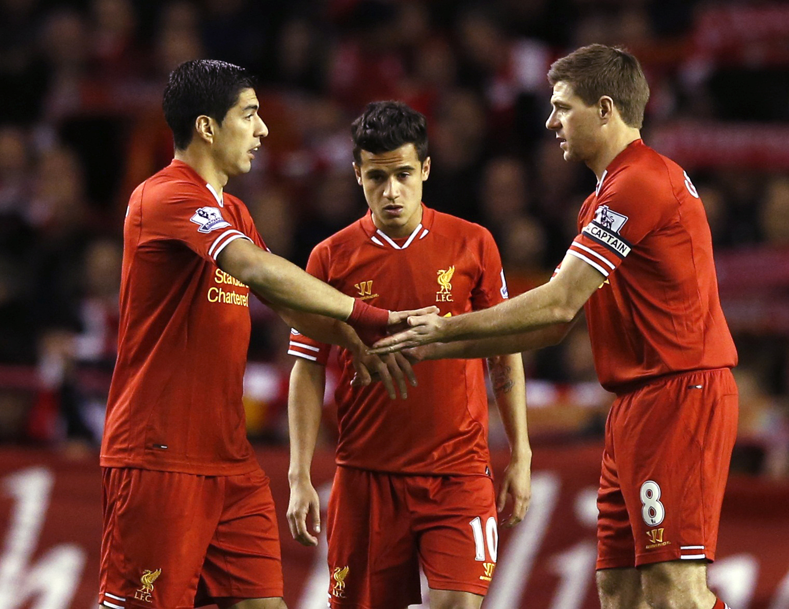Liverpool's Suarez shakes hands with teammate Gerrard as Coutinho reacts before their English Premier League soccer match against Sunderland at Anfield in Liverpool