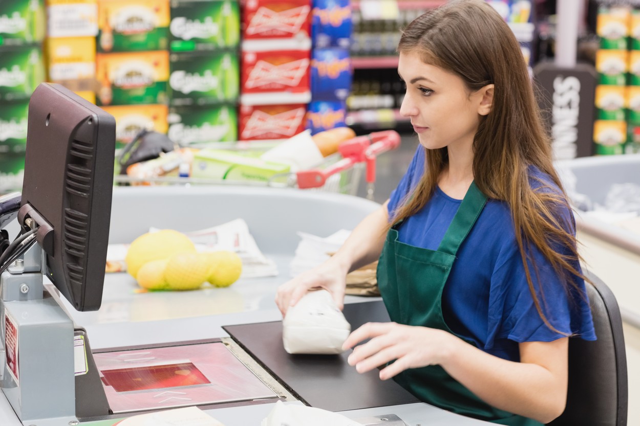 Woman cashier beeping an item