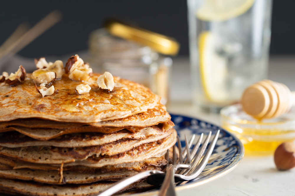 Buckwheat,Pancakes,With,Honey,And,Hazelnuts,On,An,Old,Plate.
