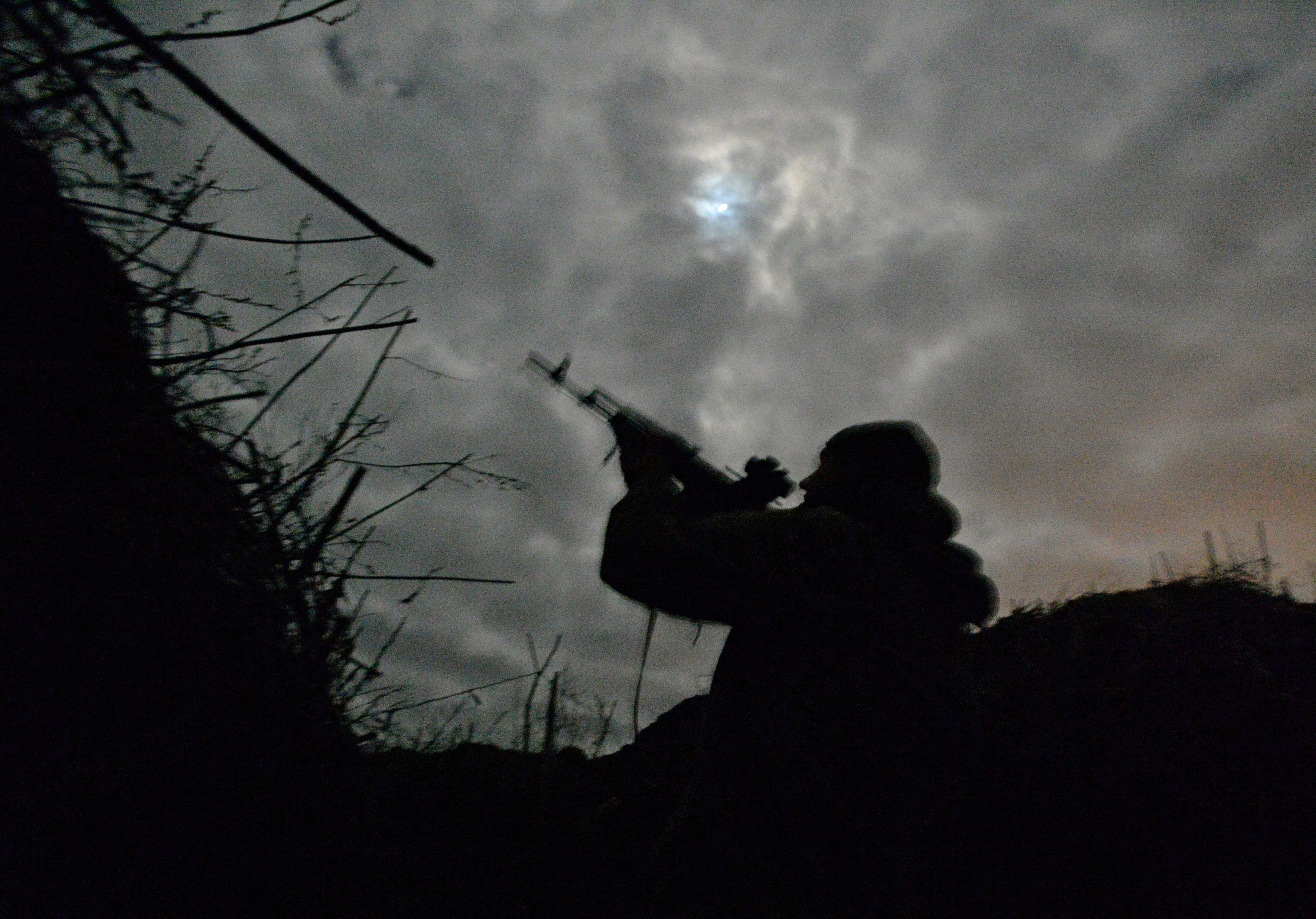 Ukrainian service members guard the area near the line of separation in the Donetsk region