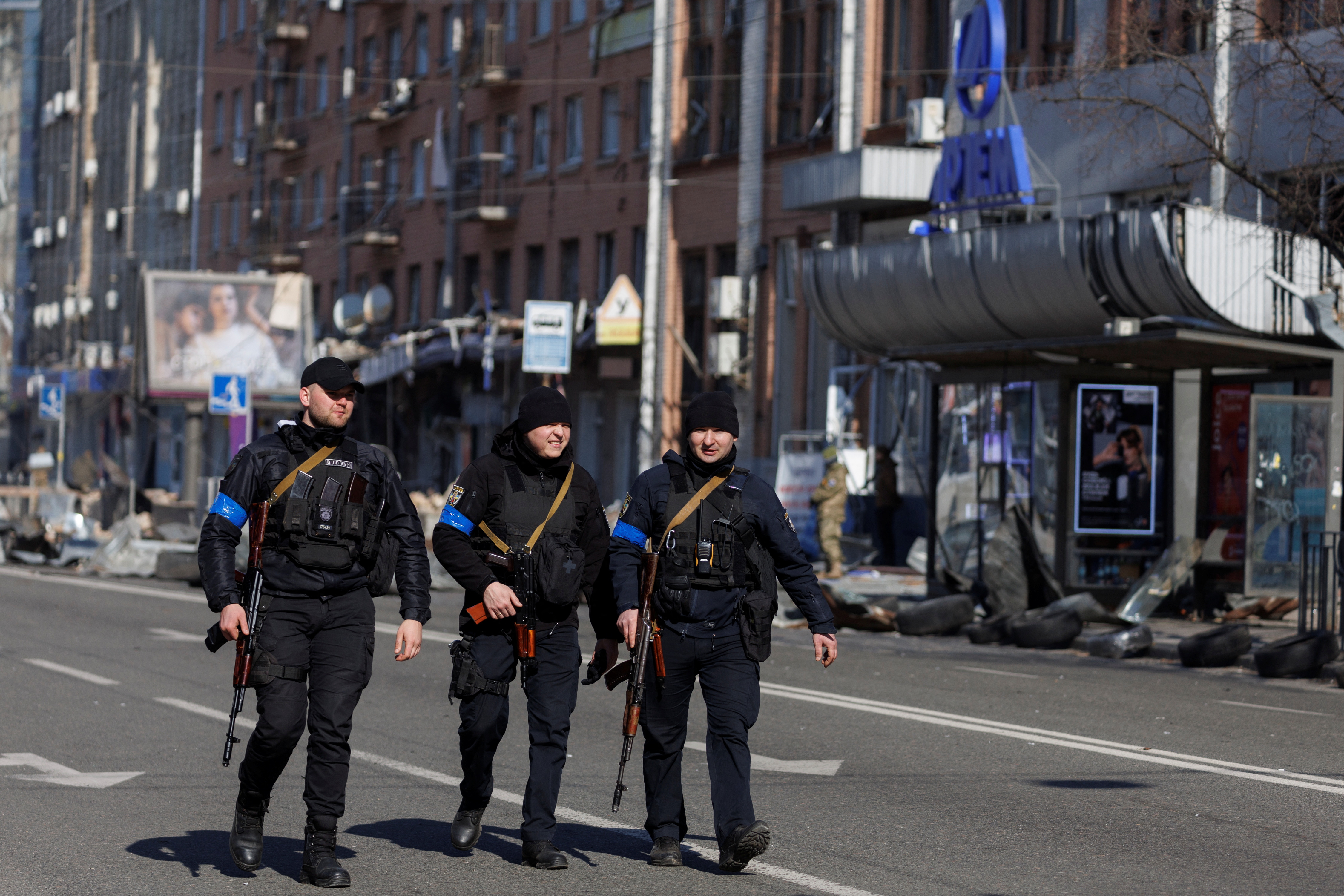 Armed police officers walk past the Artem factory in Kyiv after it was hit by shelling as Russia's attack on Ukraine continues