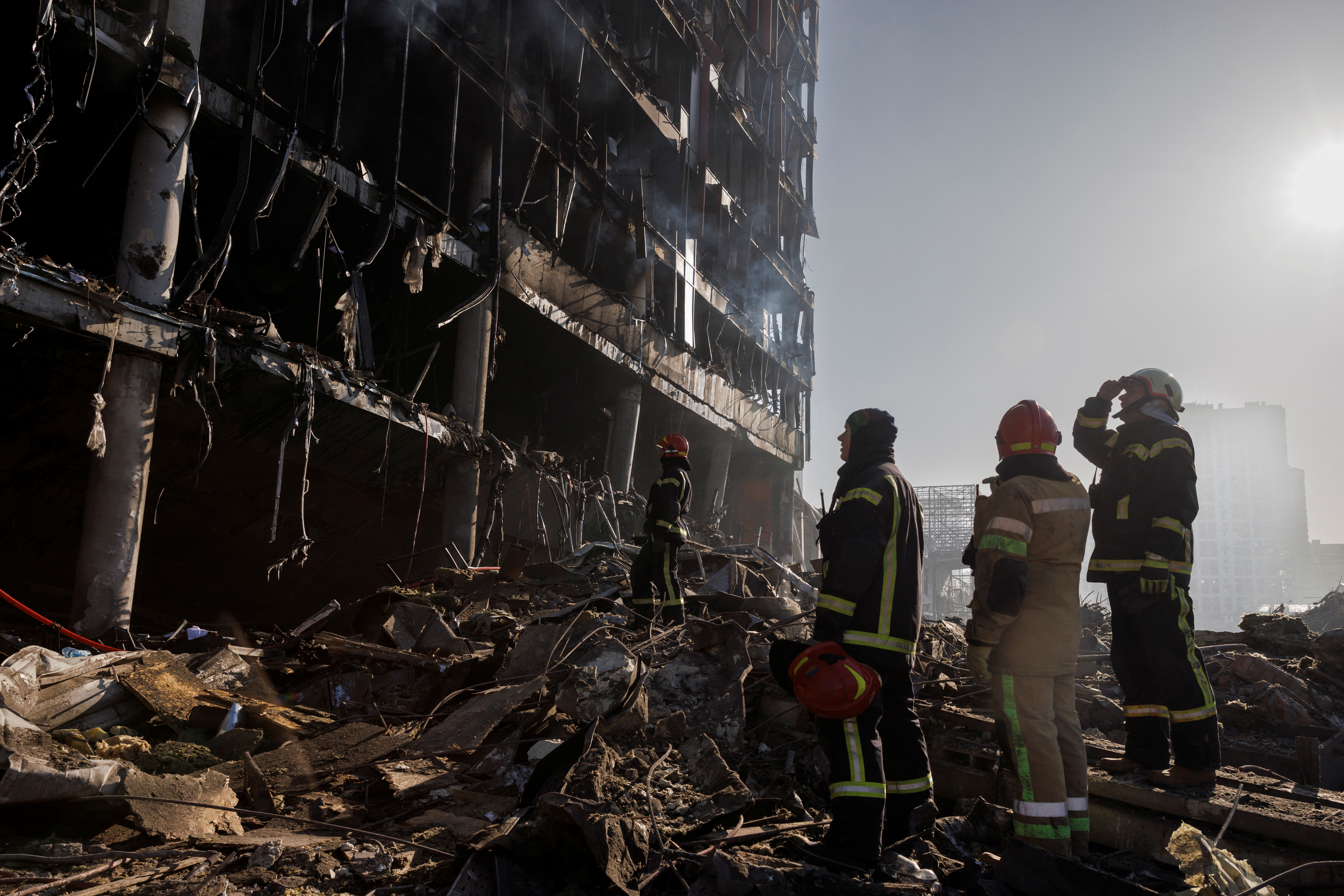 Rescue workers stand at the site of a bombing at a shopping center in Kyiv