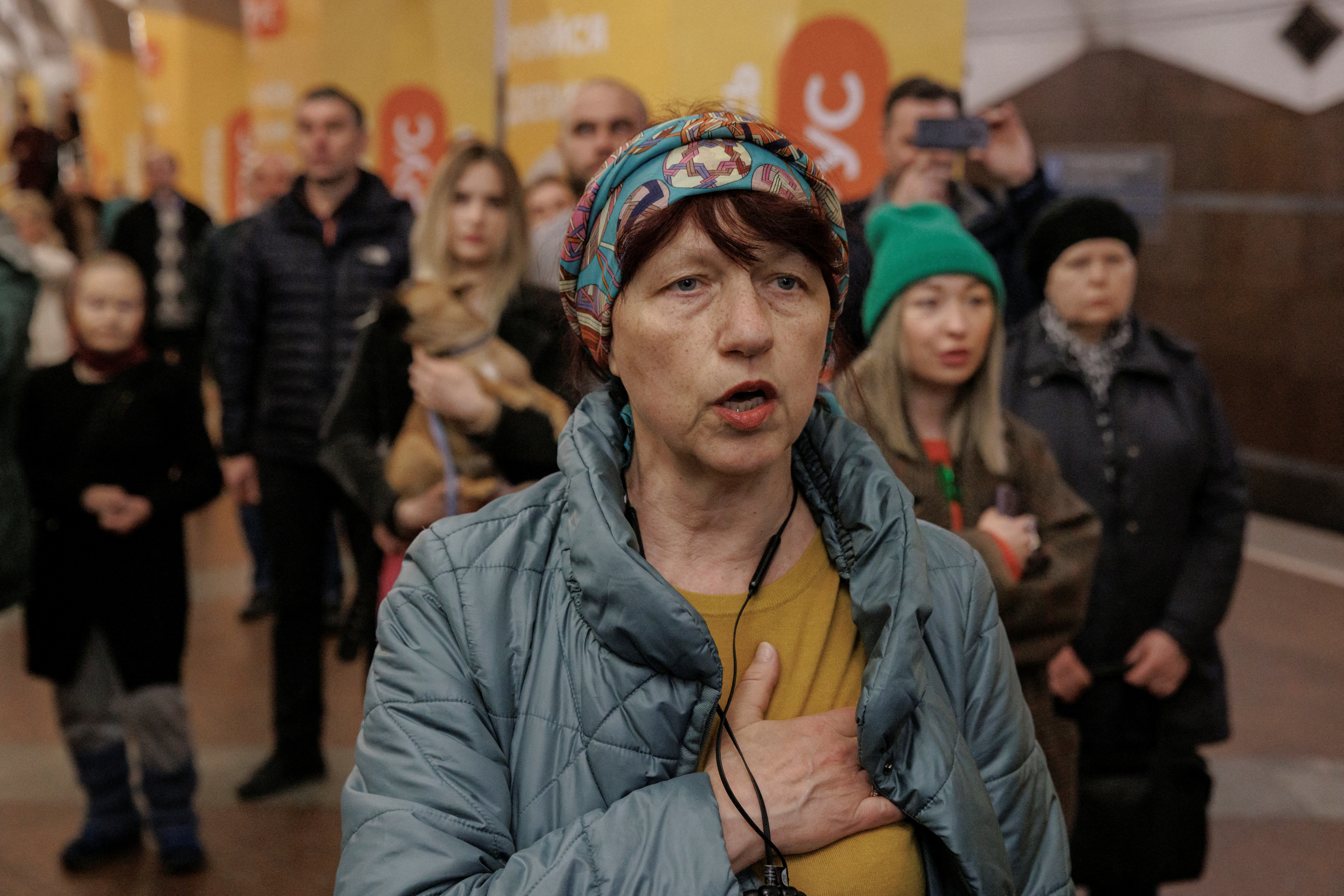 People sing Ukraine's national anthem during a classical music concert performed by local musicians in a metro station that serves as a bomb shelter, in Kharkiv