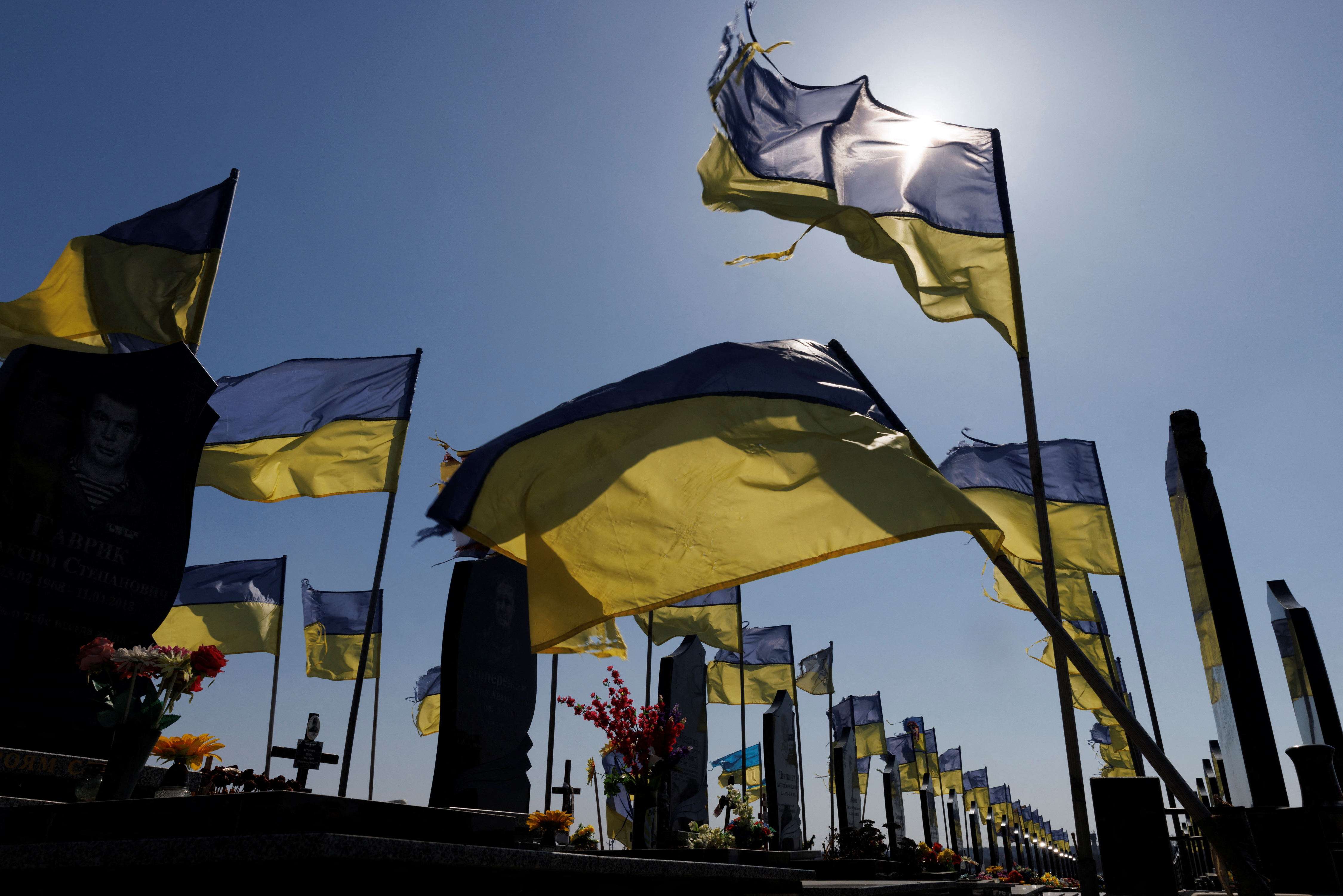 Ukrainian national flags fly over graves of fallen soldiers at a cemetery in Kharkiv as Russia's attack on Ukraine continues