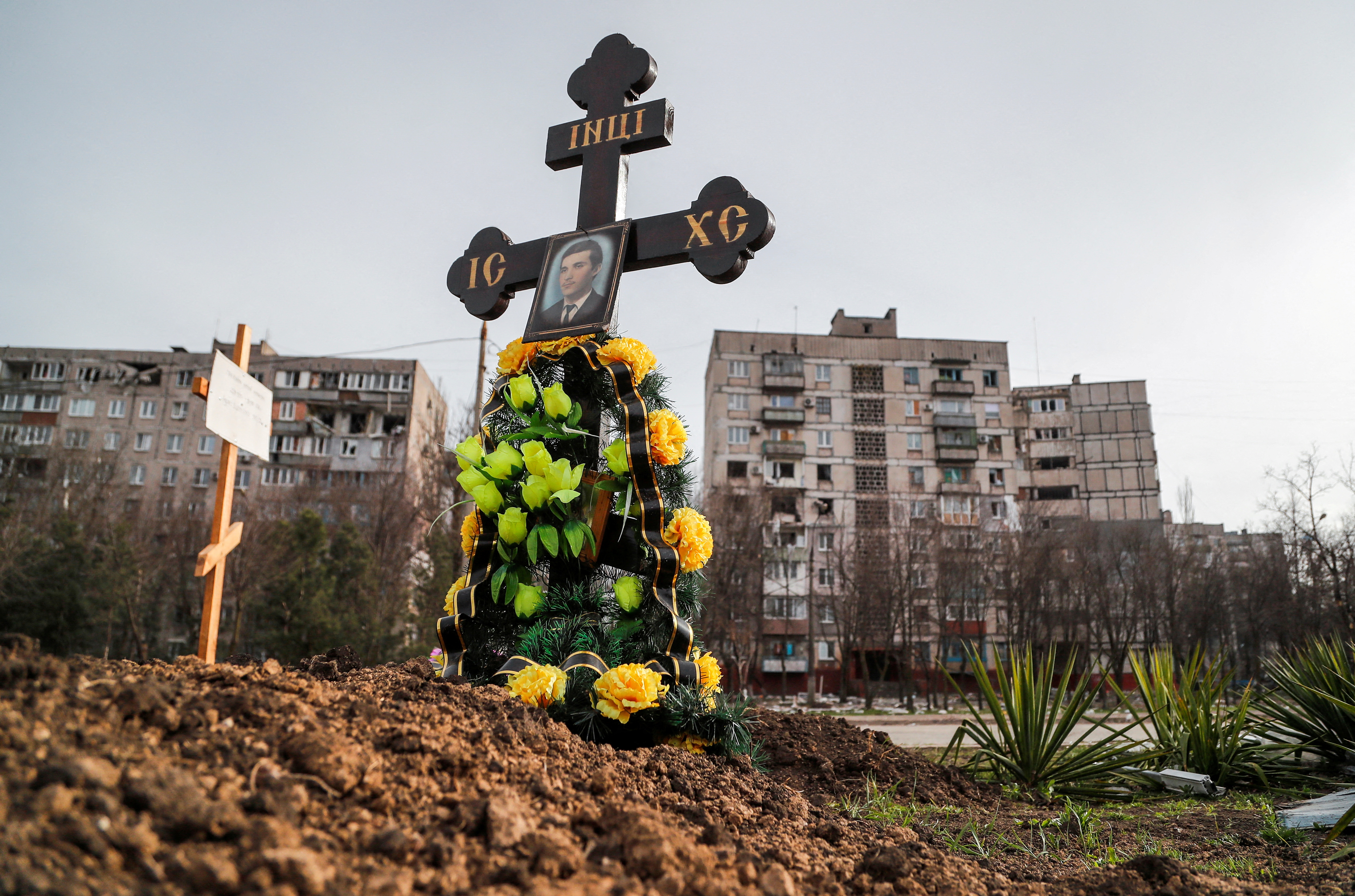 Graves of civilians killed during Ukraine-Russia conflict are seen next to apartment buildings in the southern port city of Mariupol
