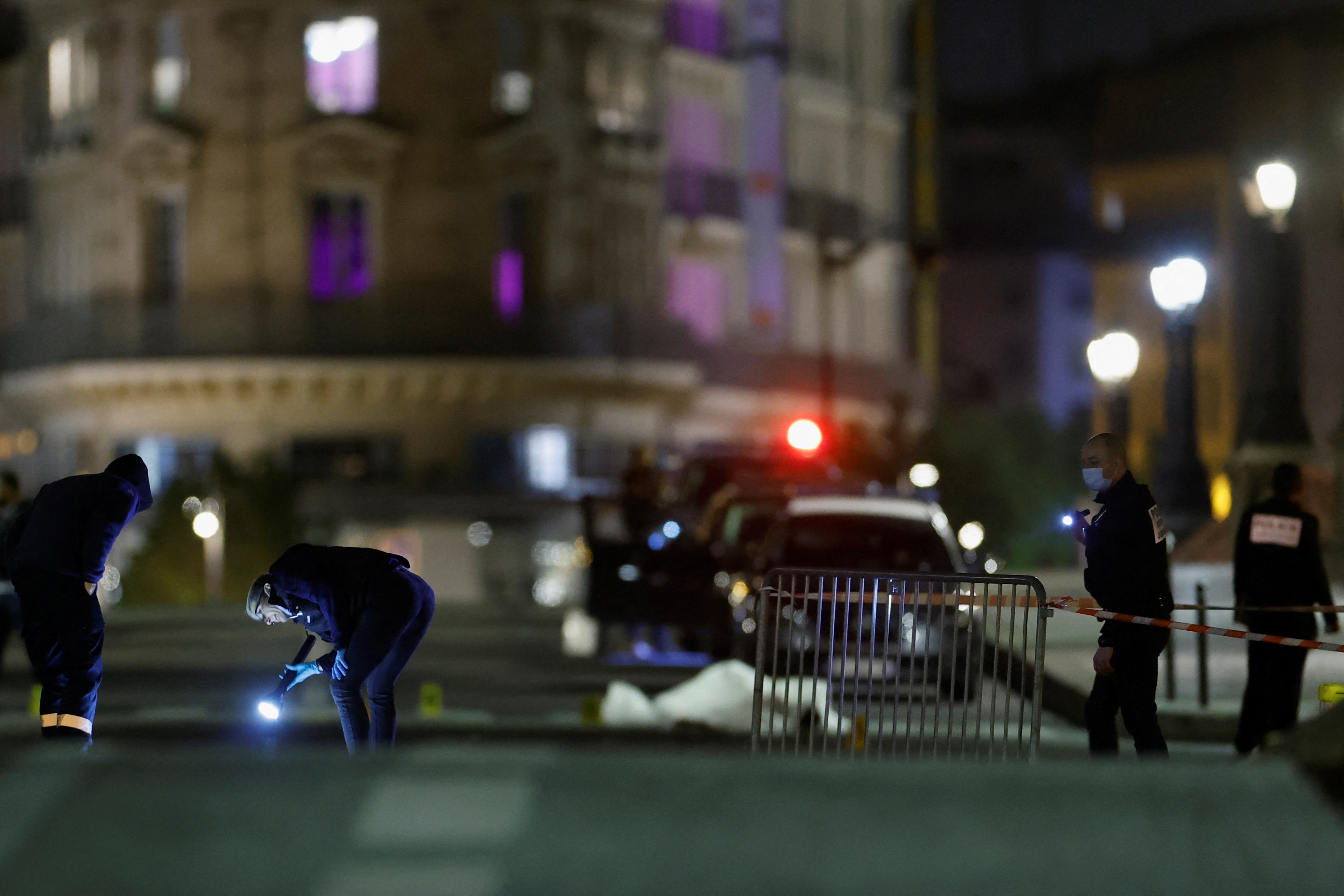 French police forensic officers inspect the scene of a shooting on the Pont Neuf bridge, in Paris