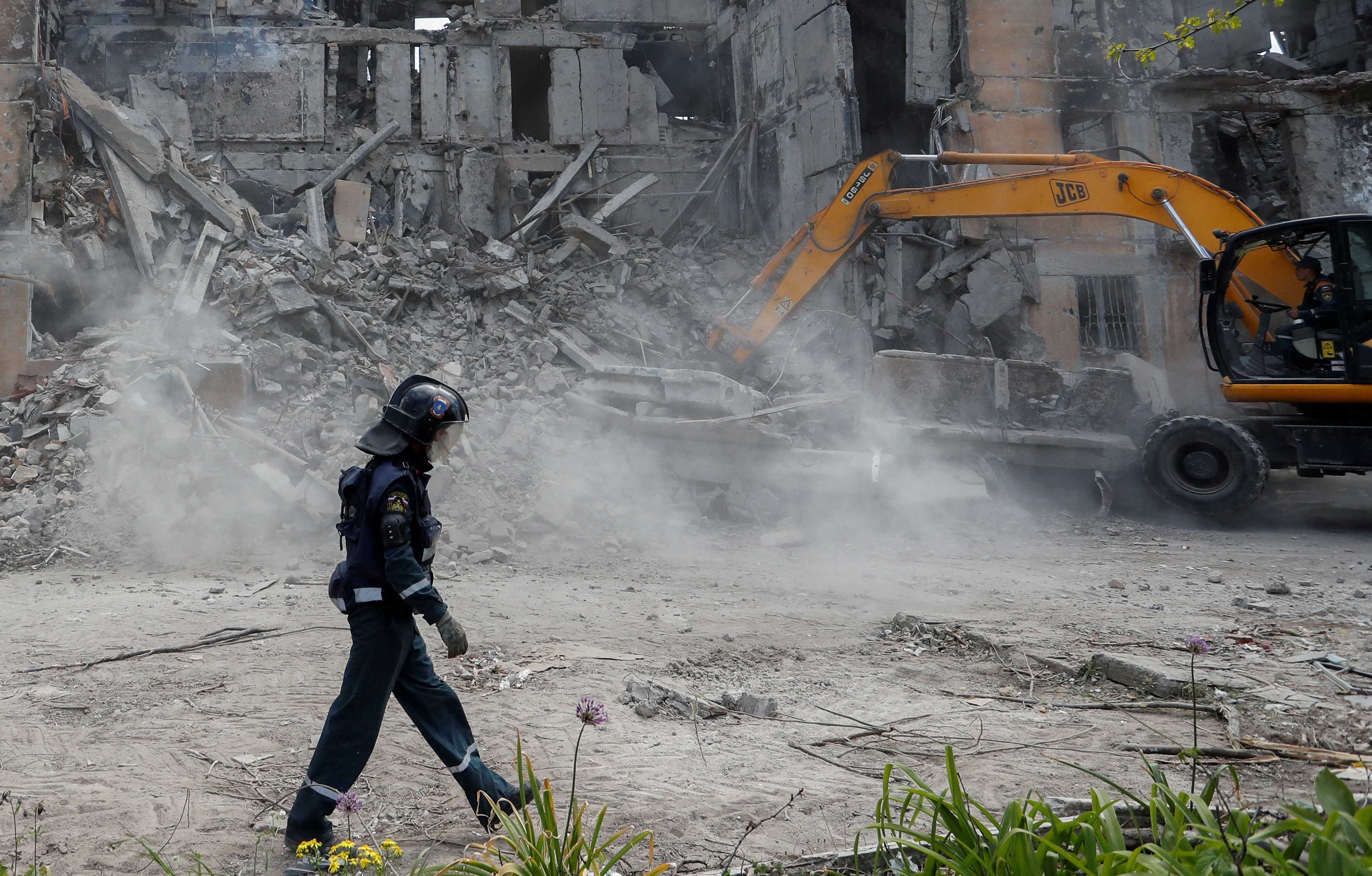 Rescuers remove debris of a destroyed residential building in Mariupol