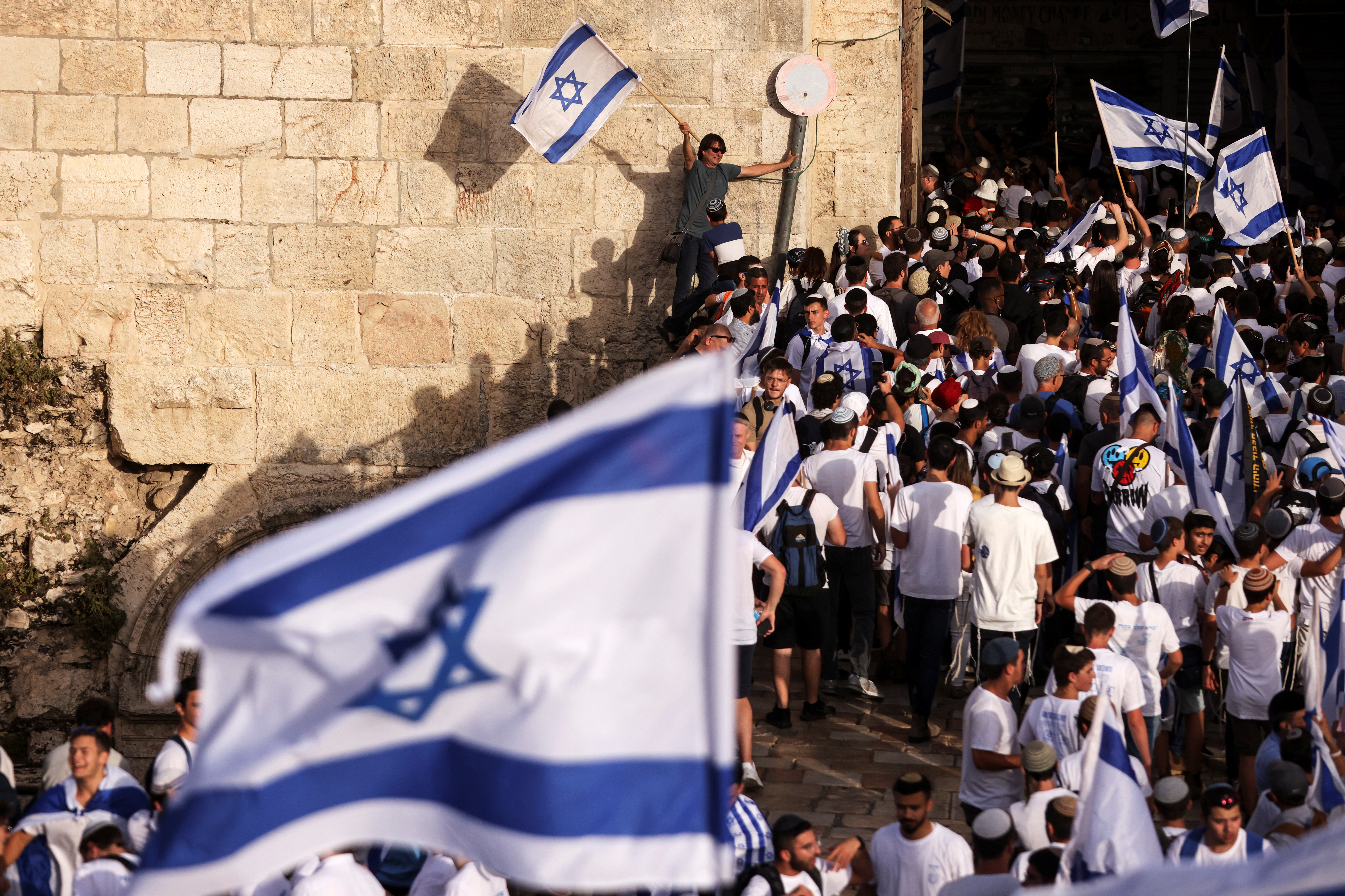 Israelis dance and sing while they hold Israeli national flags by Damascus Gate to Jerusalem's Old City
