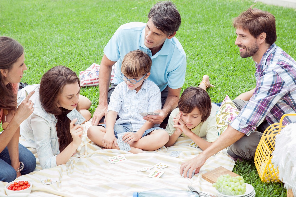 Family playing card game at picnic