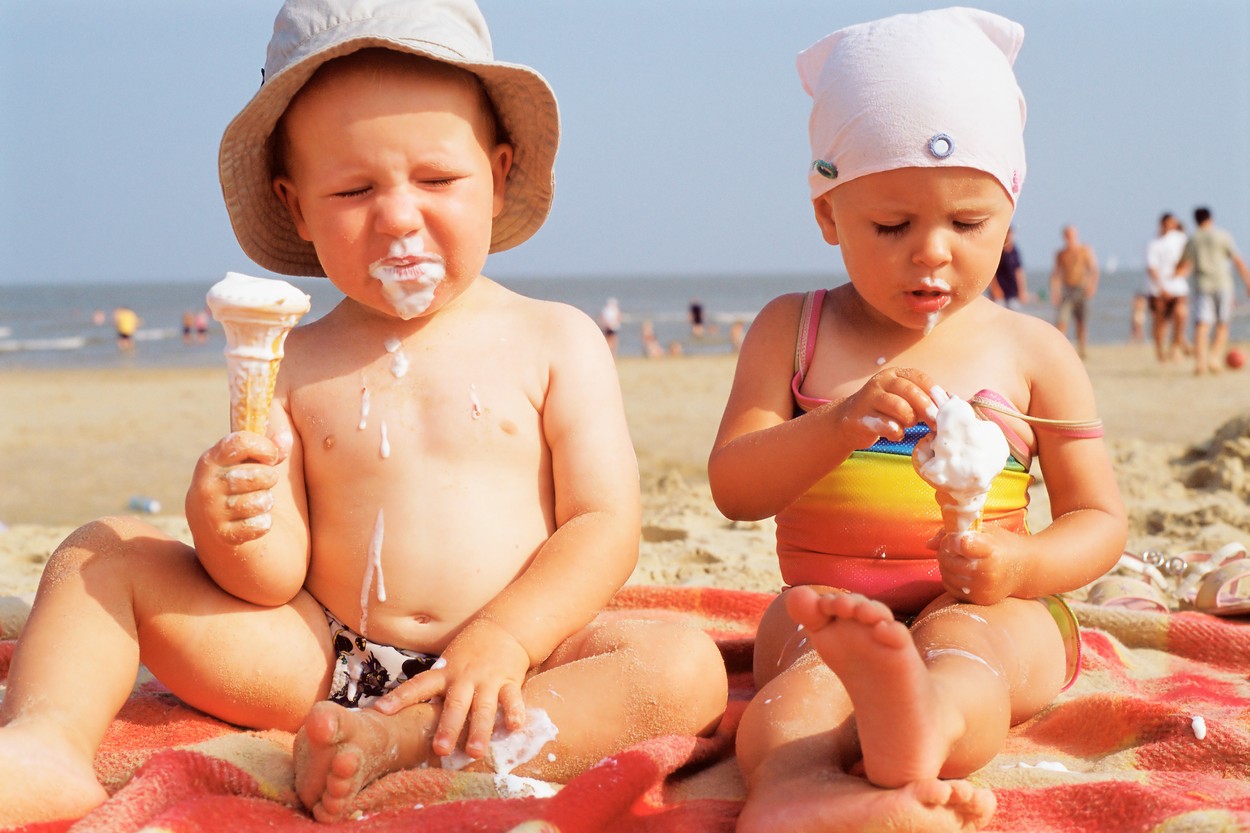 Toddlers having ice cream on the beach