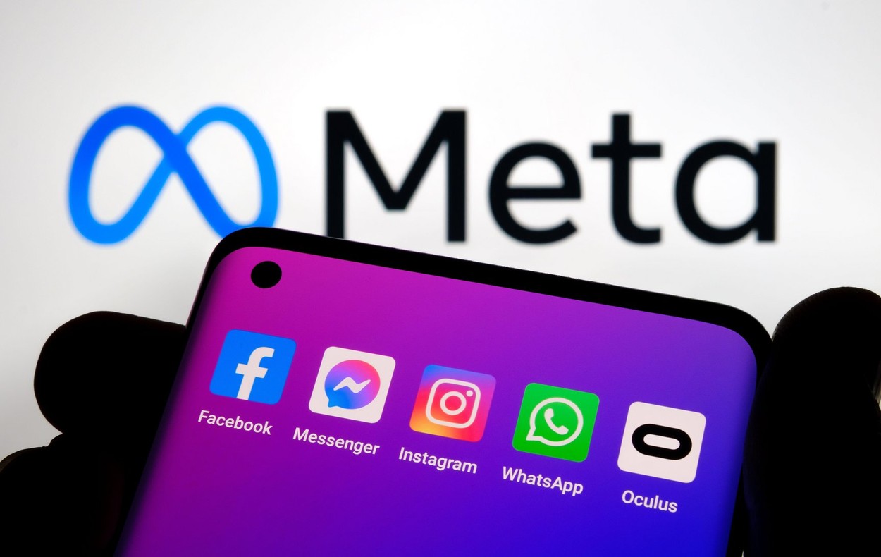 Silhouette of smartphone with Facebook, Messenger, whatsApp, Instagram, Oculus apps and blurred META company logo on the background. META is a new Fac
