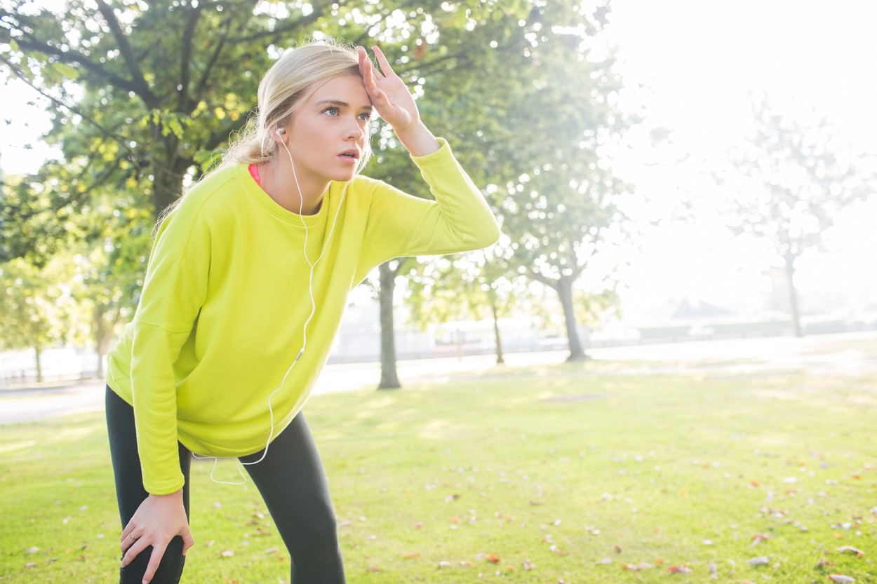 Active exhausted blonde pausing after running