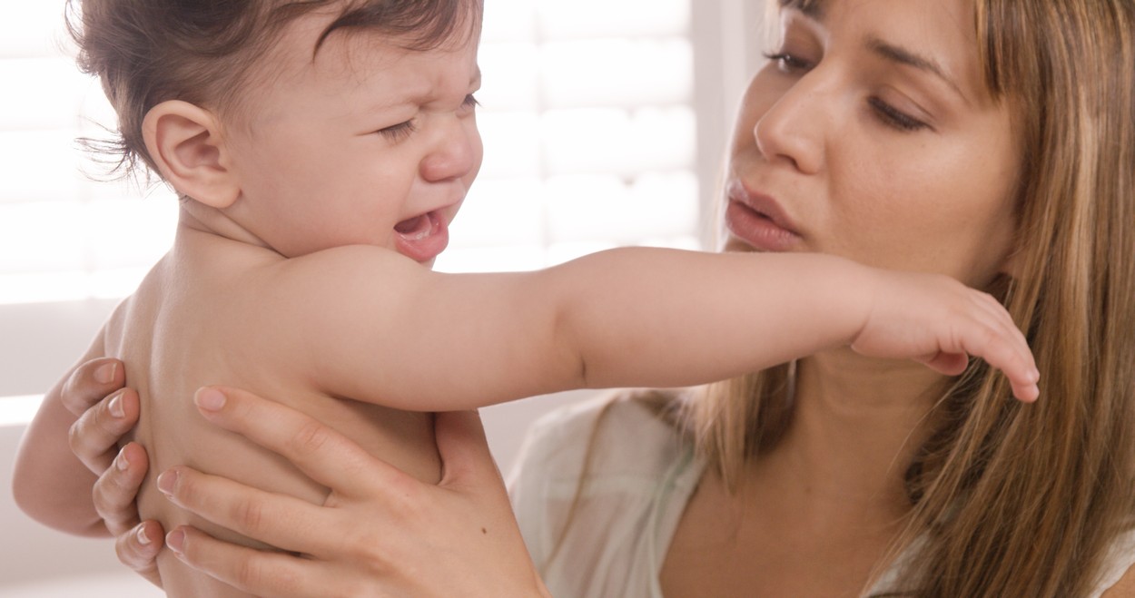 Mother carrying her baby crying