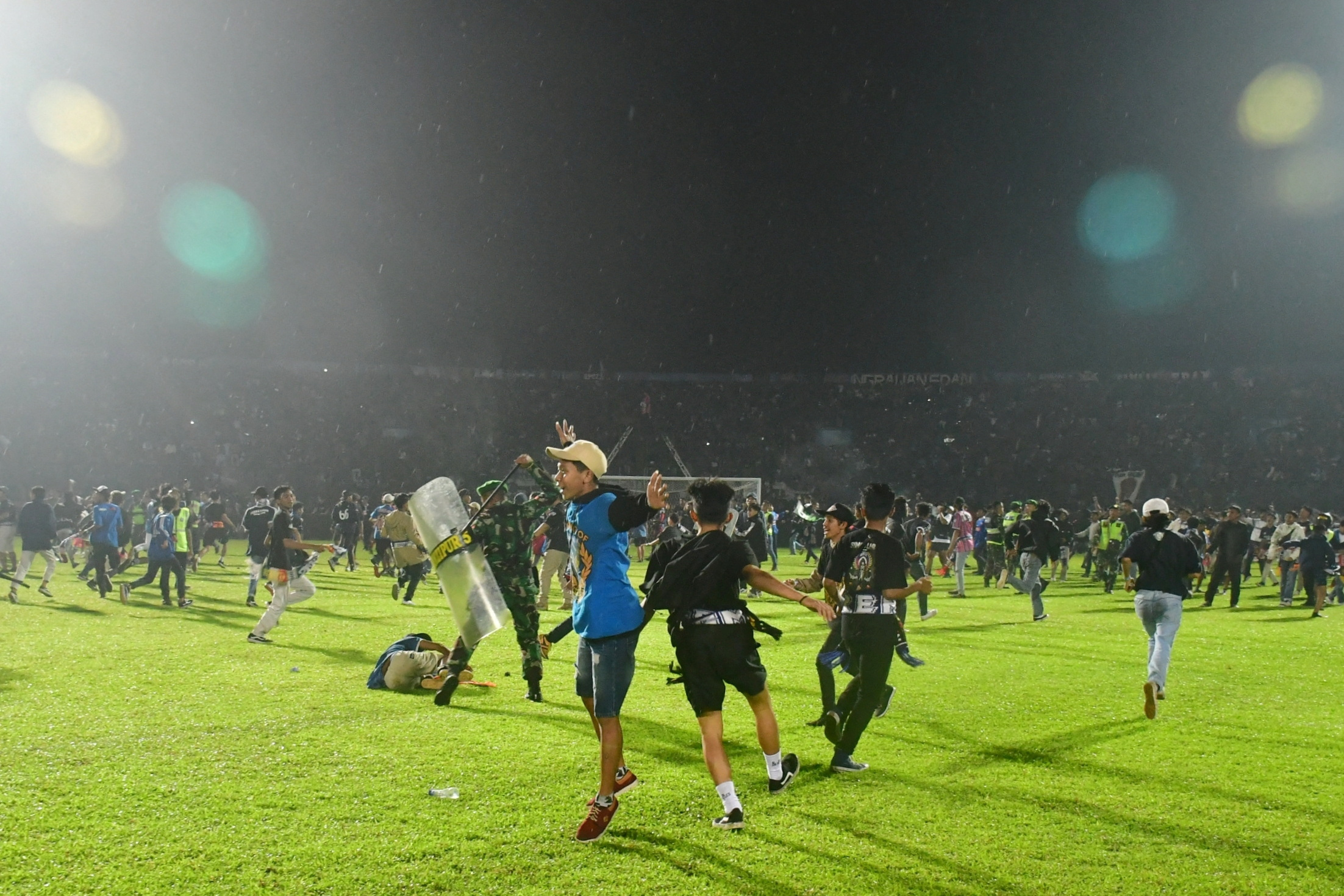 Supporters enter the field during the riot after the football match between Arema vs Persebaya at Kanjuruhan Stadium