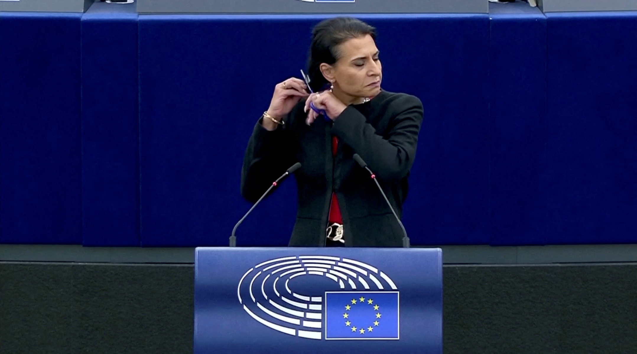 Swedish lawmaker Abir Al-Sahlani cuts her hair as she delivers a speech at EU Parliament in Strasbourg