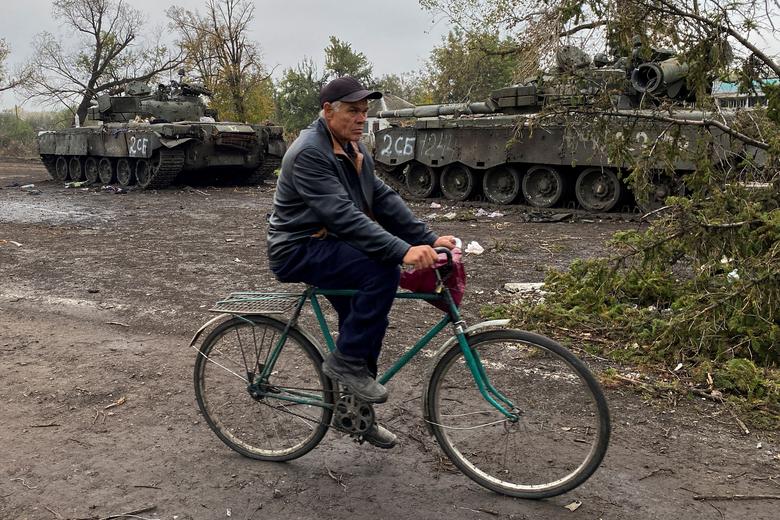 Civil vozi bicikl pored napuštenih ruskih tenkova u selu Kurilivka, u oblasti Harkov, Ukrajina, 1. oktobra. REUTERS/Vitalii Hnidyi
