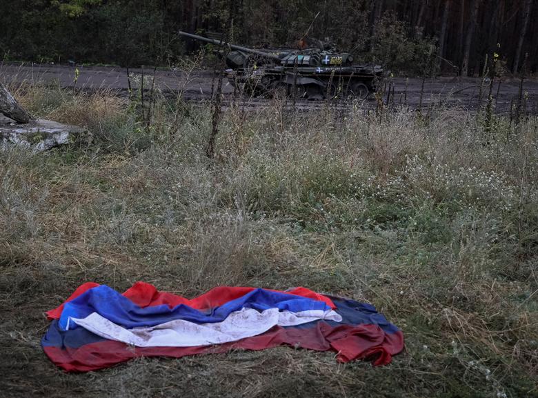 Ruska zastava na zemlji u blizini uništenog ruskog tenka u gradu Iziumu, koji su nedavno oslobodile ukrajinske oružane snage, u oblasti Harkov, Ukrajina, 14. septembra. REUTERS/Gleb Garanich

