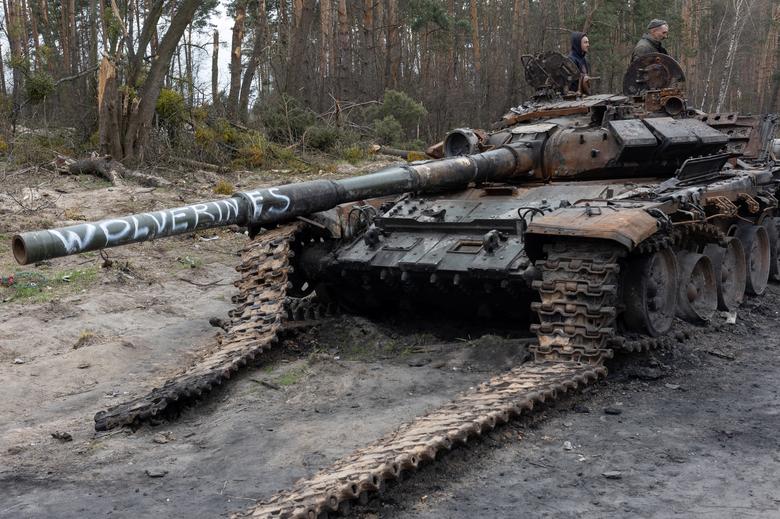 Građani traže korisne metalne dijelove u uništenom ruskom tenku ispred Kijeva, 20. aprila. REUTERS/Jorge Silva