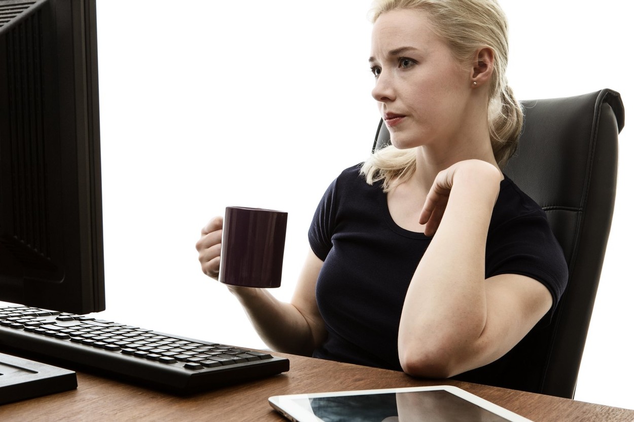 woman siting at her desk working and drink from a cup
