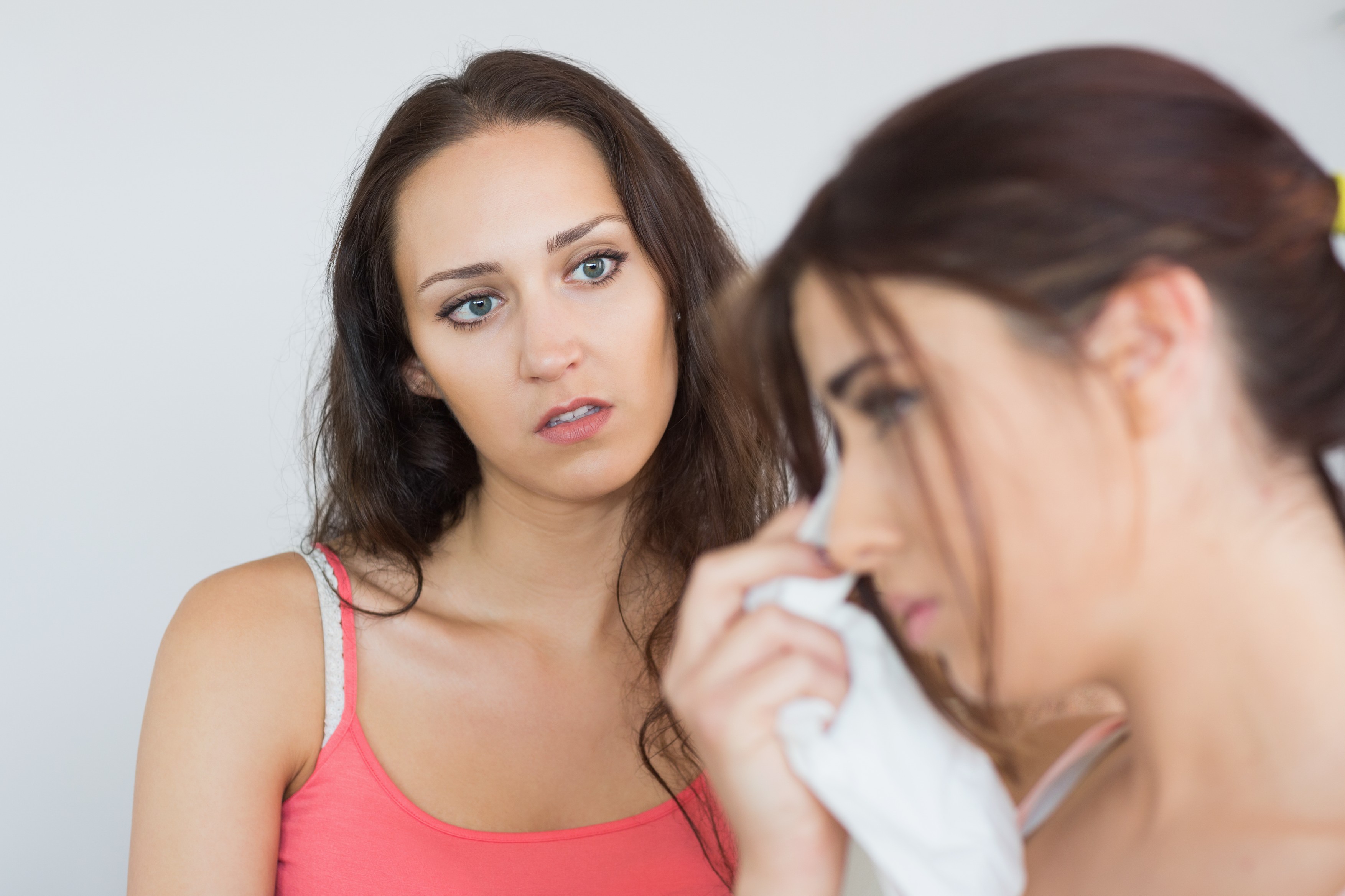 Crying woman sitting with her friend