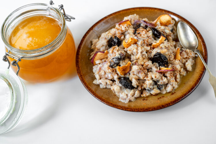 Oatmeal,Porridge,With,Apple,Pieces,,Dried,Plums,And,Honey,In