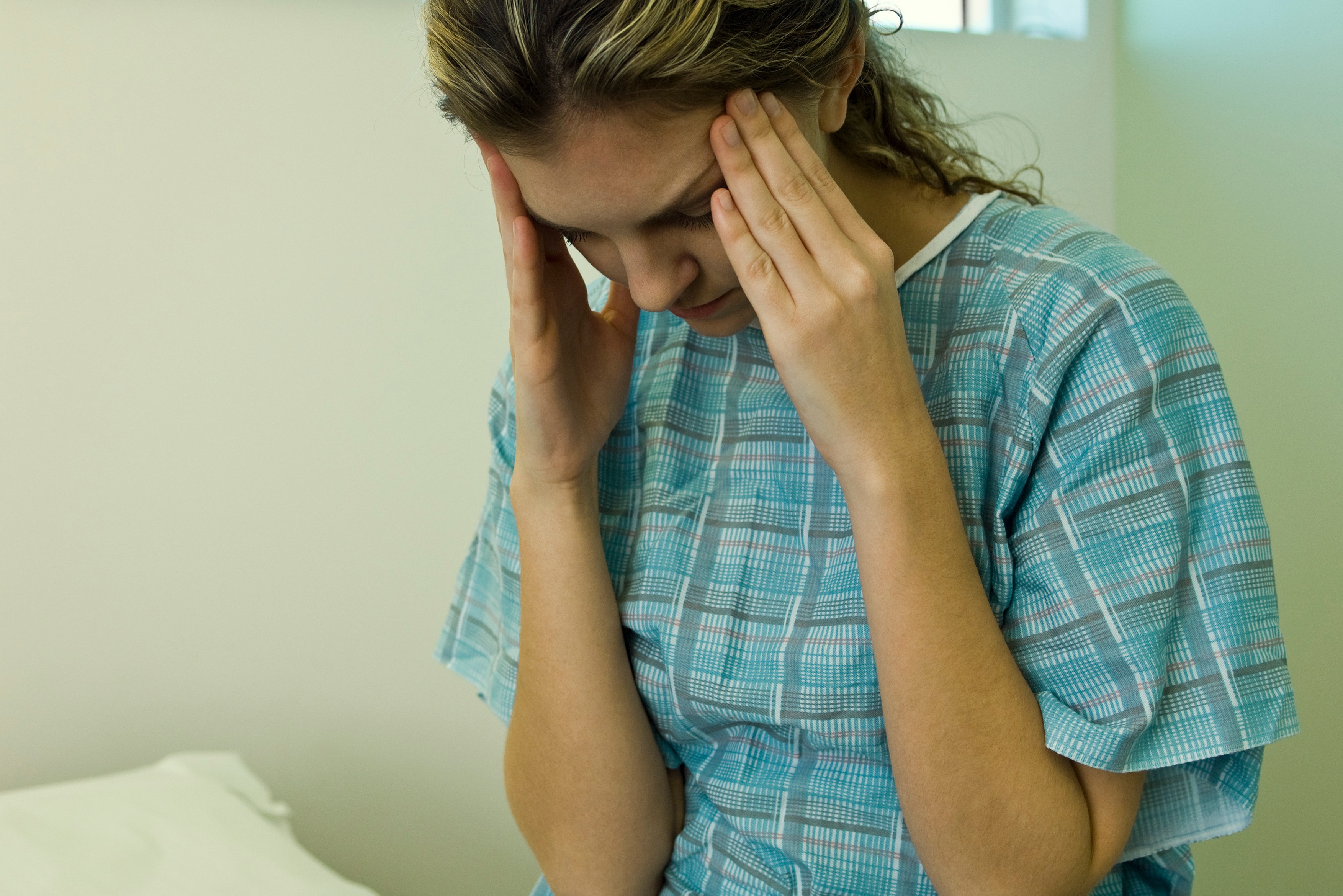 Patient with headache holding head