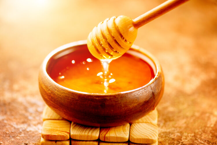med Honey,Dripping,From,Honey,Dipper,In,Wooden,Bowl.,Close-up.,Healthy